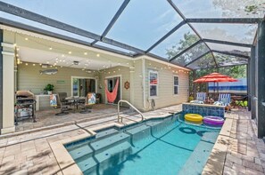 Ein überdachter Pool im Freien mit Terrasse, Grill und Lichterketten.