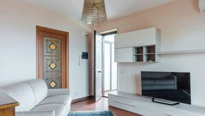 A living room with a sofa, TV, and a patterned rug. - Faraglioni Sea View Terrace by Wonderful Italy (Aci Catena)