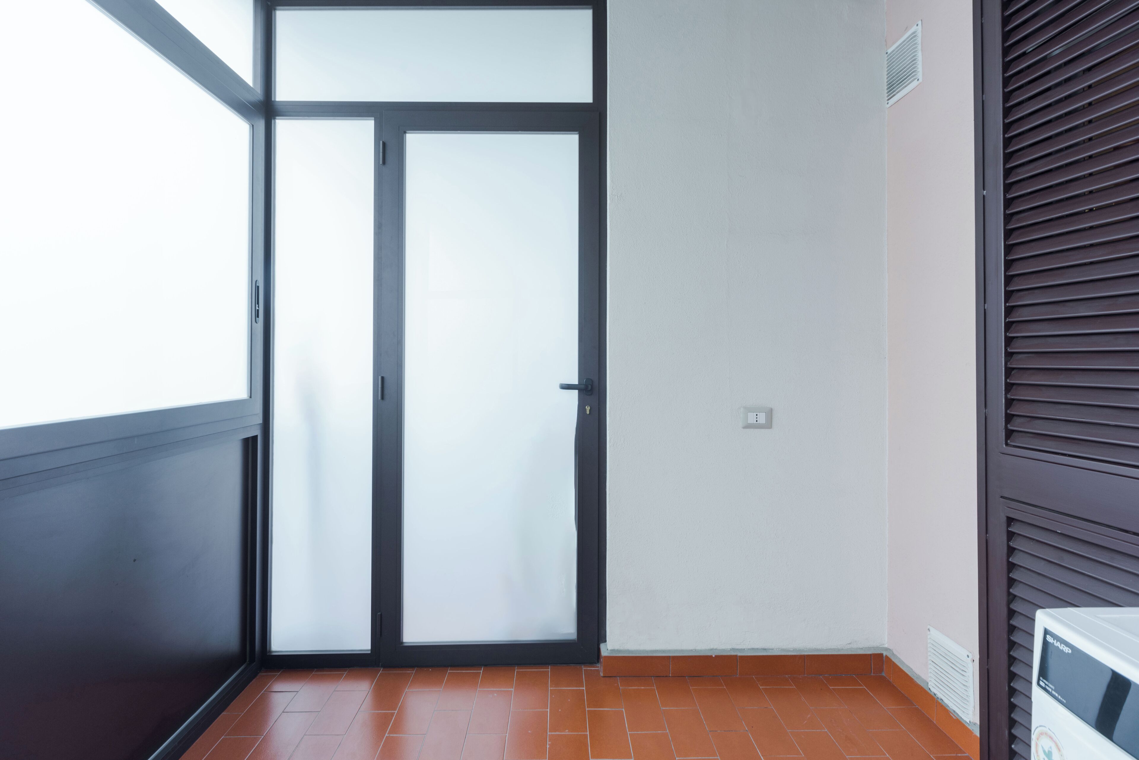 A room with a sliding glass door, a radiator, and a tiled floor.