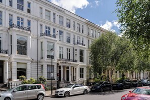 A multi-story building with a classic architectural style, featuring large windows and balconies. - Earl's Court - Your Apartment (London)