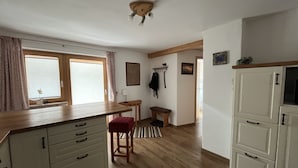Una cocina con armarios de madera, una banca, una mesa y una lámpara en el techo.
