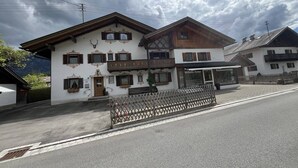 Ein traditionelles Chalet mit Holzhülle, zahlreichen Fenstern und einem Balkon.