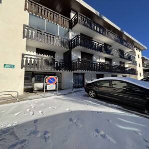 A multi-story building with balconies, a no parking sign, and a car parked in front. - Vrbo Property (Saint-Lary-Soulan)