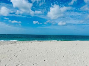 Ein Strand mit weißem Sand und blauem Himmel.