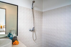 A bathroom with a shower, a sink, and toiletries. - Tropical Oasis Villa – Steps from Seminyak Beach (Seminyak)