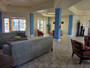A spacious lobby with a grey sofa, armchairs, and a coffee table. - Newly Renovated!  4-bedroom with pool near Disney and Universal Parks (Davenport)