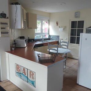 Una cocina con barra, un lavamanos, una ventana y una puerta.