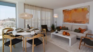 Ein modernes Wohnzimmer mit einem runden Esstisch, Sofas und einem großen abstrakten Gemälde.