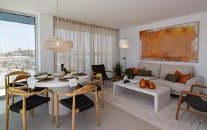 Ein modernes Wohnzimmer mit einem runden Esstisch, Sofas und einem großen abstrakten Gemälde.