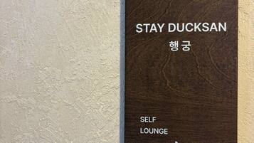Un cartel con la leyenda 'STAY DUCKSAN' y 'SELF LOUNGE', que indica una zona de sala de espera con servicio propio.