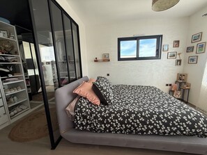 A bedroom with a bed, a wardrobe, a window, and wall decorations.