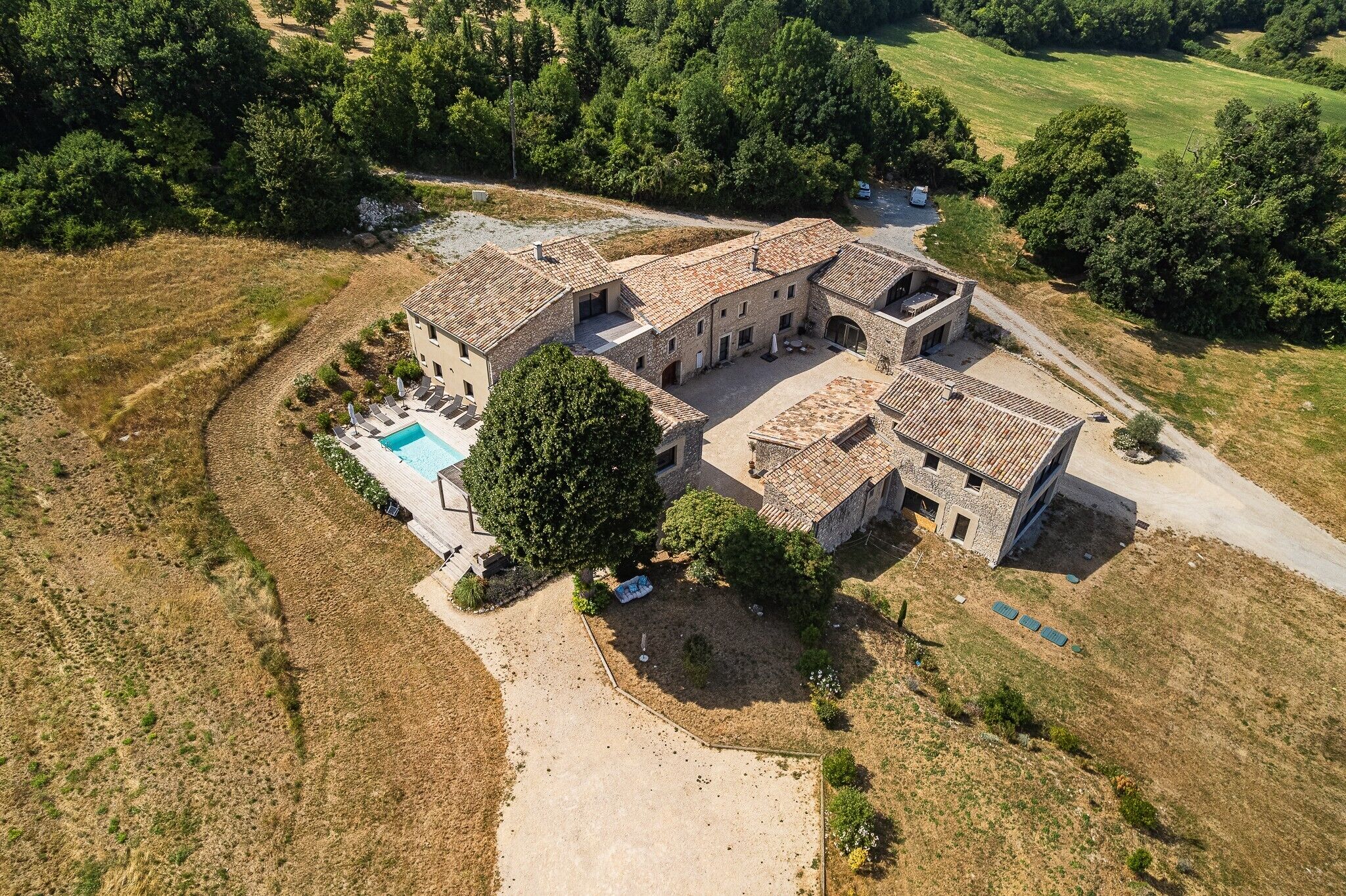 A large stone building with a swimming pool and outdoor seating area.