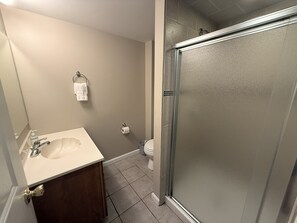 Un baño con lavamanos, inodoro y ducha.