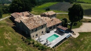 Una vila amb piscina, jardí terrassat i vista al camp.
