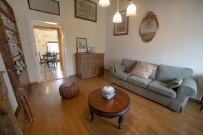 A living room with a sofa, a coffee table, and a wooden cabinet. - Poetic Florence - Spacious Central Home: 3-BR, 2-Bath, Lift, View & Parking (Firenze)