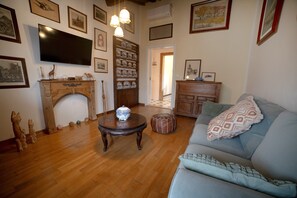 Una sala de estar con chimenea, televisor y sofá.