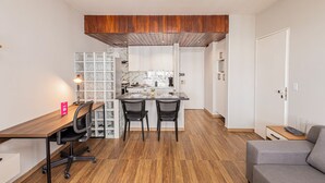 Une cuisine compacte avec un coin repas, un plafond en bois et un petit espace salon.