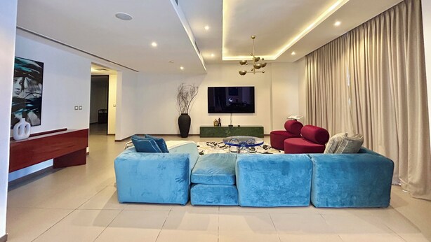Una sala de estar moderna con un sofá modular, un televisor de pantalla plana y un diseño minimalista.