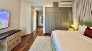 Una habitación de hotel con cama, televisión instalada en la pared, armario y aire acondicionado.