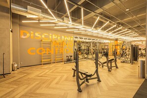 A gym with exercise equipment, wooden flooring, and motivational wall text. - VNM - VN Vila Olimpia by Anora Spaces (São Paulo)
