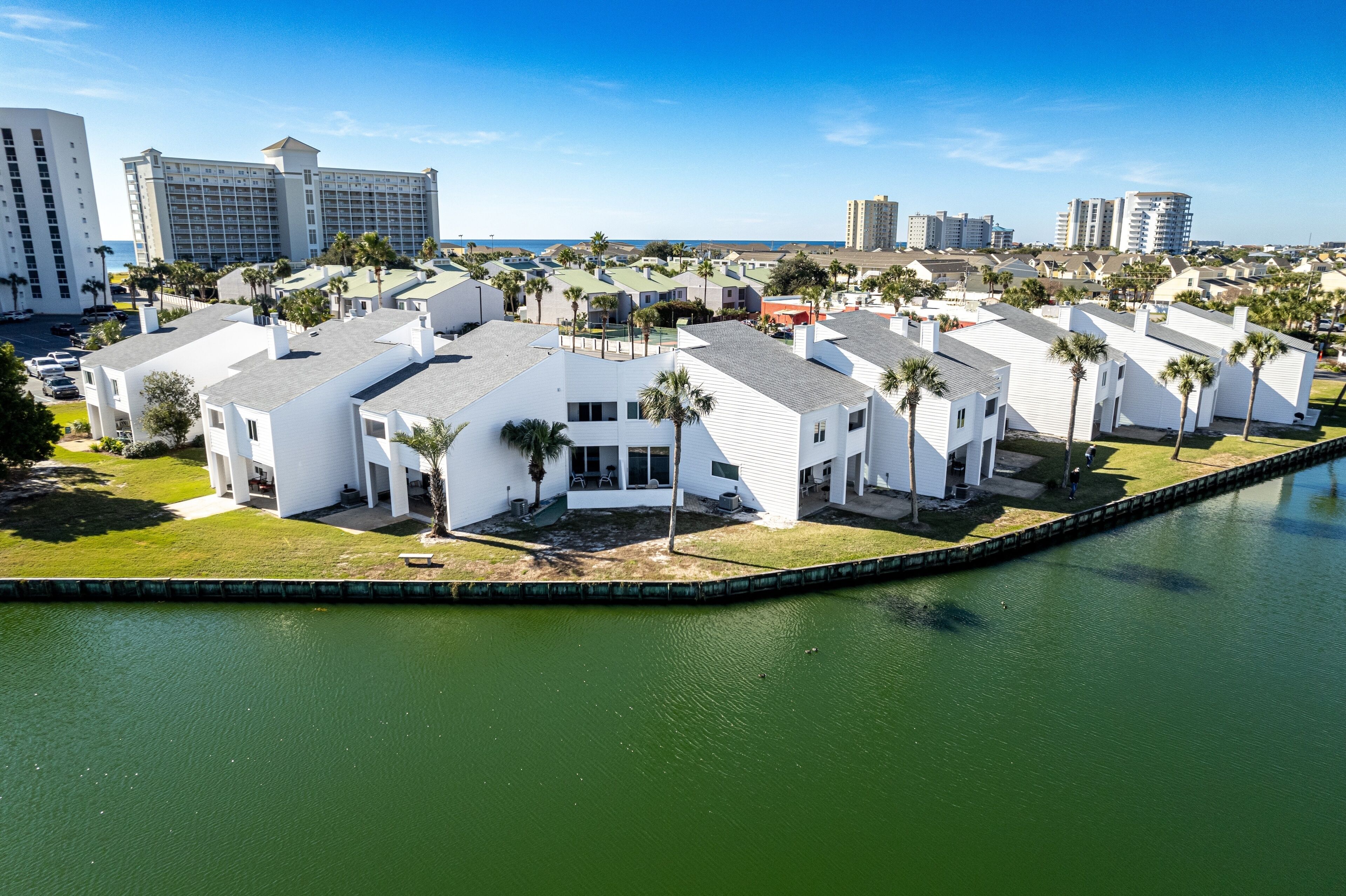 Ein Küstenhotel mit weißen Gebäuden, einer Marina und Blick auf das Meer und die Stadtlandschaft.