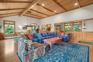 A spacious living room with a large sectional sofa, a coffee table, and a dining area with a table and chairs. - Beachcomber's Retreat *Beach*Golf*Pets (Gearhart)