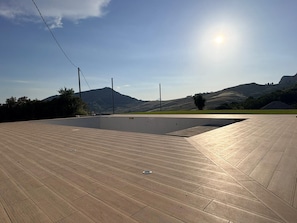 Una terraza en la azotea con vistas a colinas ondulantes y una montaña al fondo.