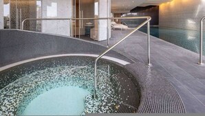 A modern indoor swimming pool with a glass enclosure, a hot tub, and a spa area. - Waterfront Luxury Apt With Pool Gym Concierge (London)
