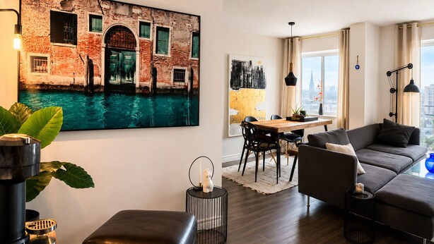 Un soggiorno moderno con un quadro di grandi dimensioni, un'area pranzo e un divano.