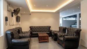 Una sala de estar moderna con sofás de cuero, una mesa de centro de madera e iluminación empotrada en el techo.