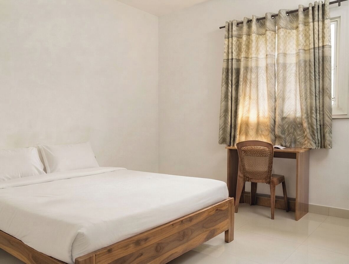 A bedroom with a wooden bed, a desk, and a chair.