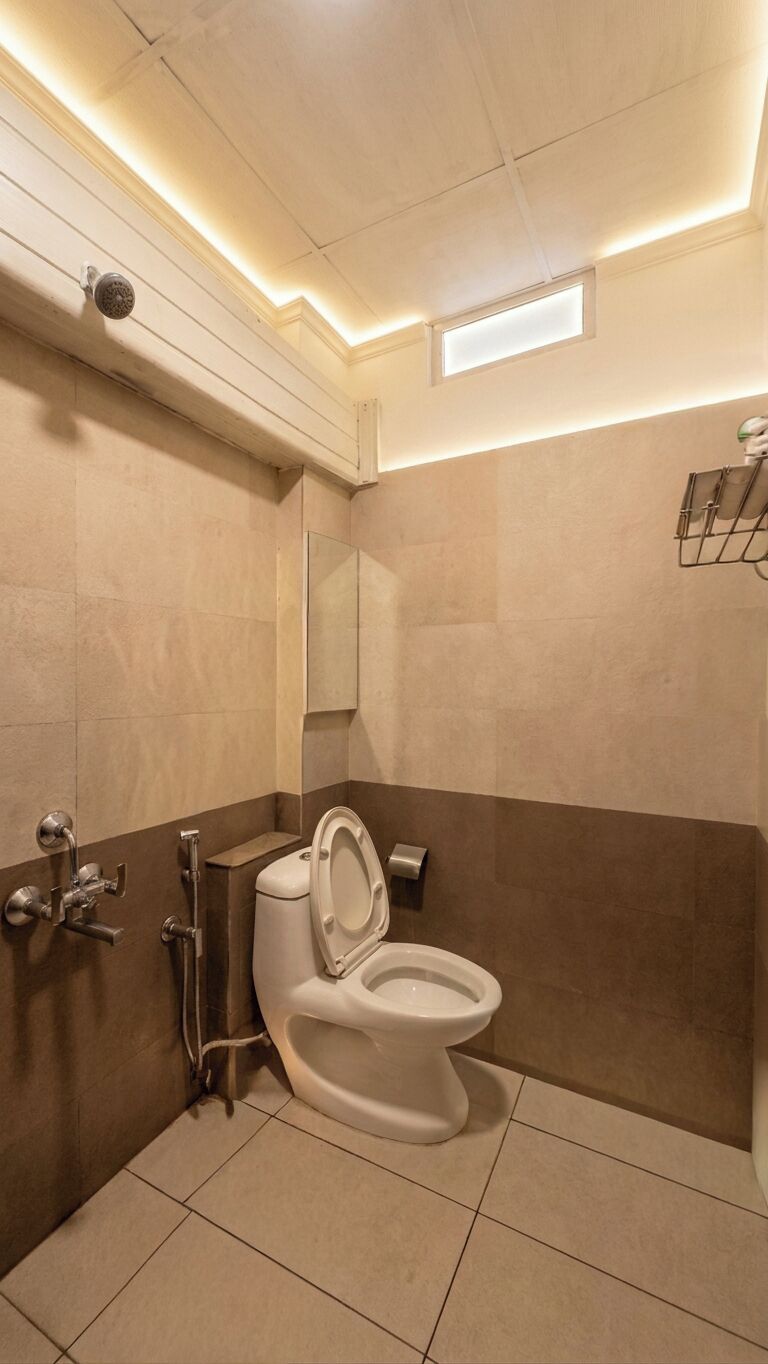 Een badkamer met toilet, douche en spiegel.