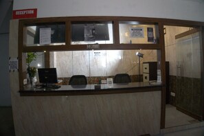 A reception desk with a sign indicating 'RECEPTION' and a notice about items not being responsible for over 7 days. - Crest Wood Inn (Kanayannur)