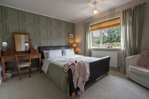 A bedroom with a bed, dresser, chair, and a window with curtains. - Wisteria Corner, Large Tranquil Family Home, Spacious, Edge of the Peak District (Chesterfield)
