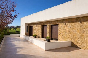 Un edificio moderno con fachada de piedra, ventanas amplias y techo plano.