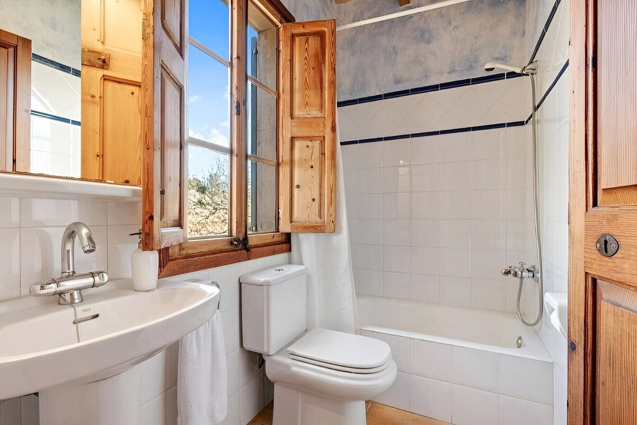Een badkamer met wastafel, toilet en douche.