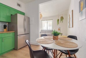 Una cucina moderna con mobili verdi, un frigorifero bianco e utensili da cucina.