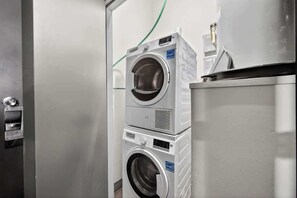 A laundry facility with stacked washing machines and dryers. - DT Dallas · Sleeps 12 · Pool · Gym · Views · Valet (Dallas)