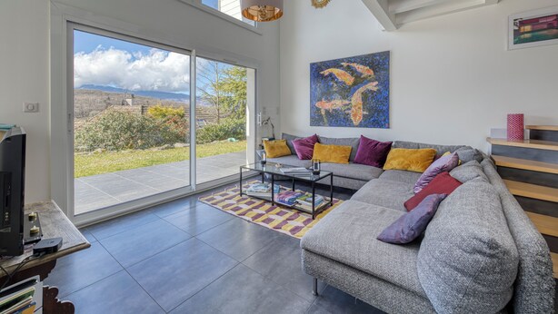 A modern living room with a sofa, a coffee table, and a large window with a view of a garden and mountains. -
Luxurious Villa Ella Talloires (Talloires-Montmin)