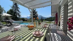 A dining table set outdoors with a view of mountains, a pool, and greenery. -
Luxurious Villa Ella Talloires (Talloires-Montmin)