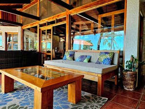 A spacious living area with a sofa, a glass coffee table, and a wooden bench. - Villa Bonita – Luxury Secluded Mountain Retreat in Costa Rica (Provincia de Guanacaste)