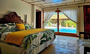 A bedroom with a bed, a view of a swimming pool, and a door leading outside. - Villa Bonita – Luxury Secluded Mountain Retreat in Costa Rica (Provincia de Guanacaste)