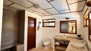 A bathroom with a shower, toilet, and two sinks with a stone countertop. - Villa Bonita – Luxury Secluded Mountain Retreat in Costa Rica (Provincia de Guanacaste)
