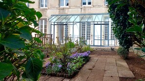 A conservatory with a glass roof, surrounded by a garden with various plants and flowers. - Apartment Quimper hyper-centre, 3 bedrooms (Quimper)