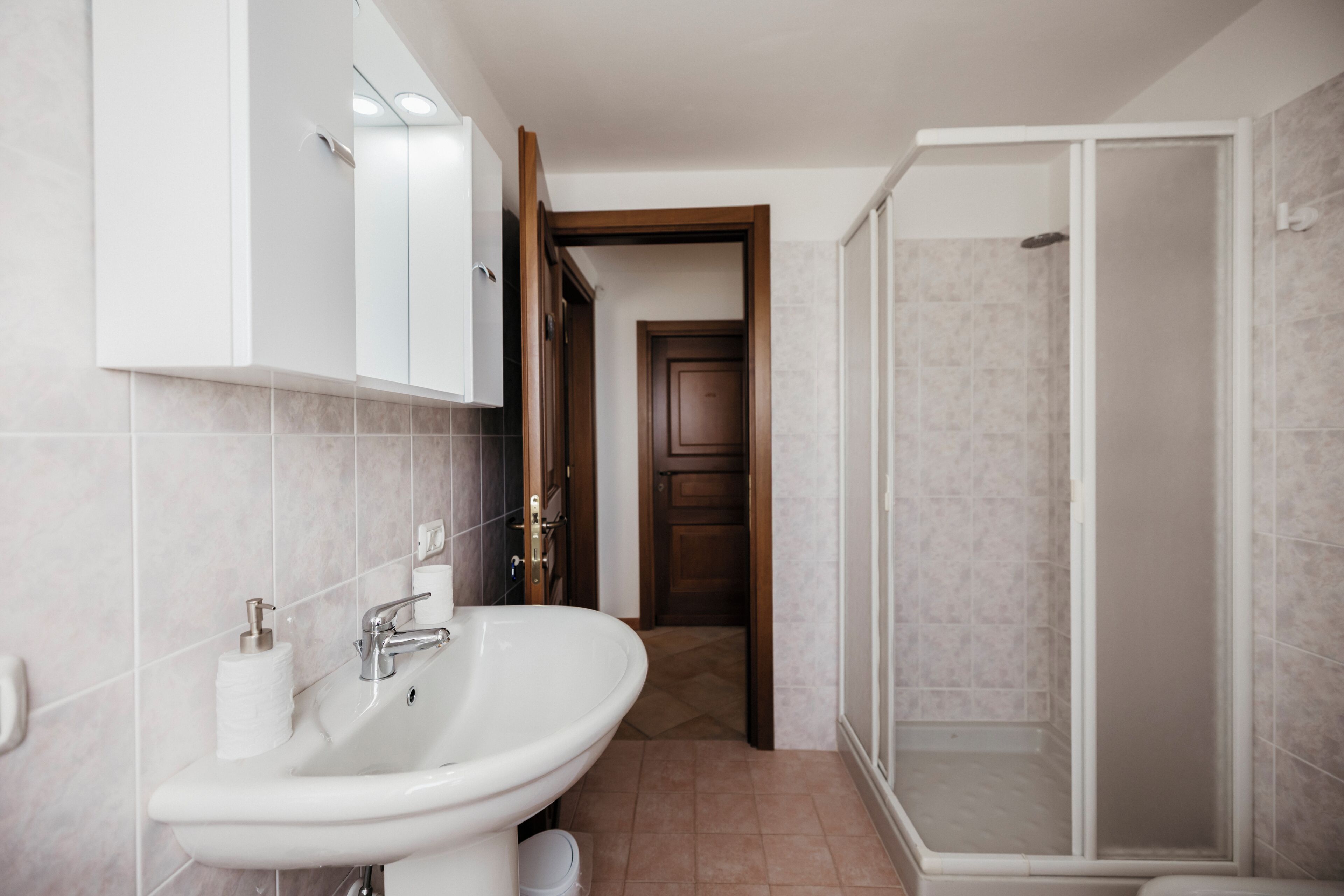 A bathroom with a sink, mirror, and shower.