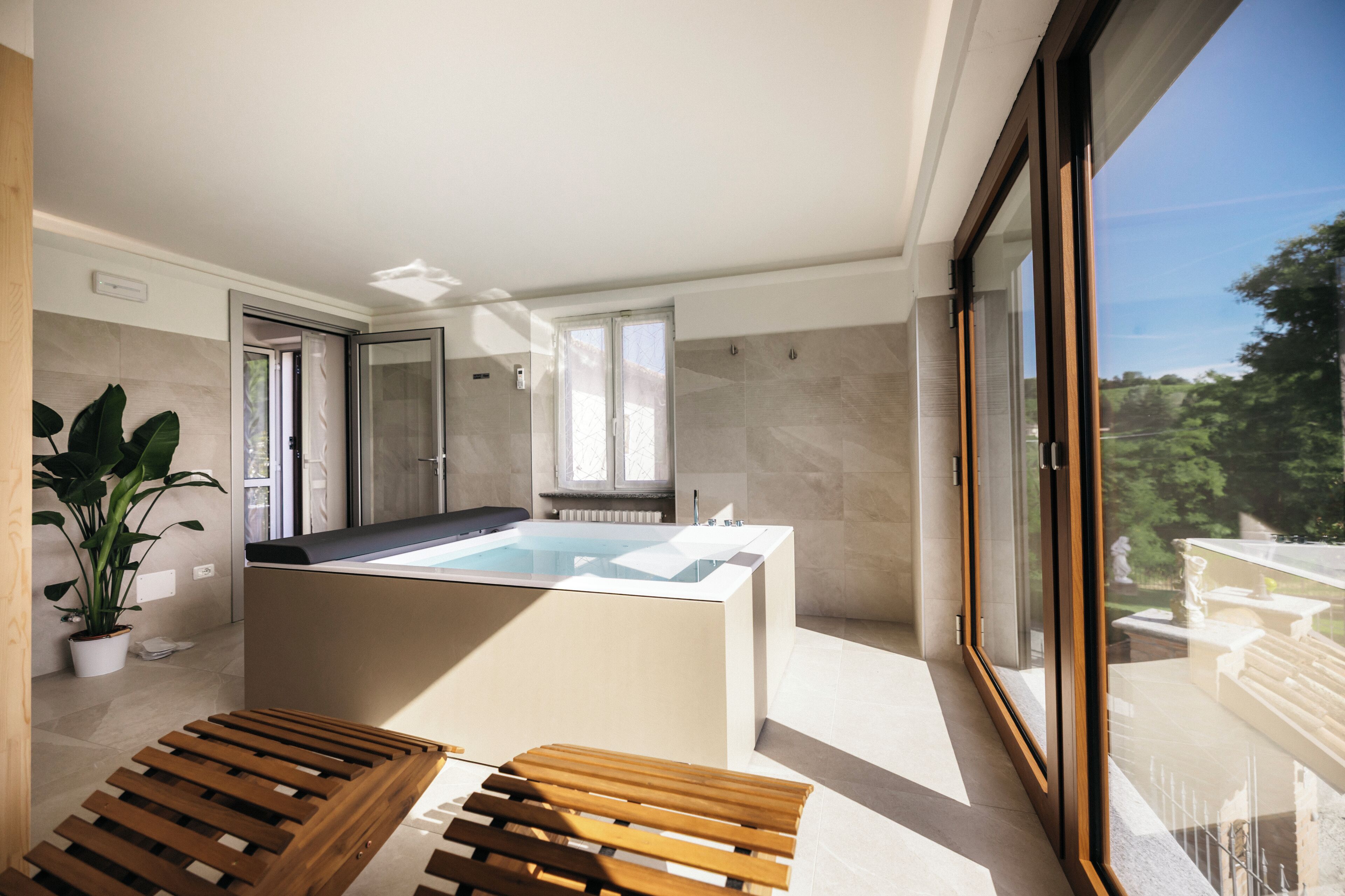 Ein modernes Badezimmer mit einer Badewanne, einer Dusche und einem Fenster.