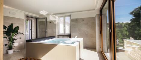 Ein modernes Badezimmer mit einer Badewanne, einer Dusche und einem Fenster.