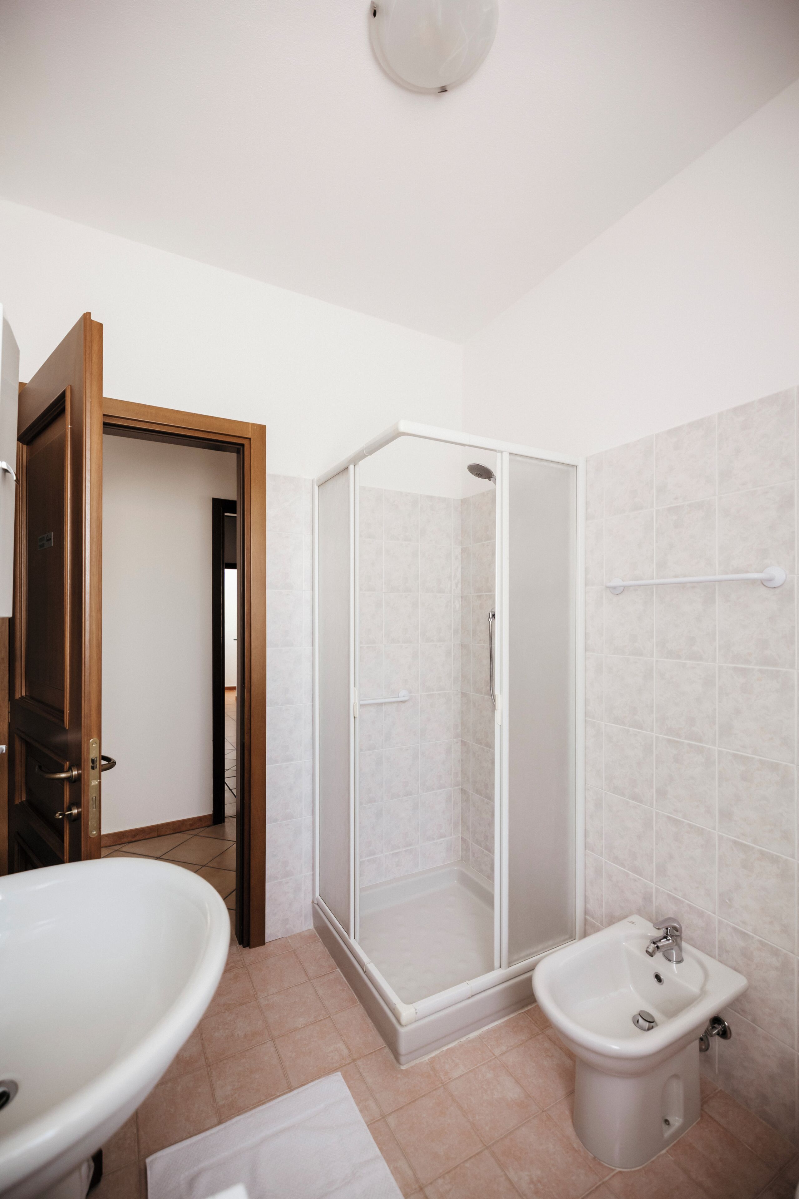 A bathroom with a shower, a sink, and a toilet.