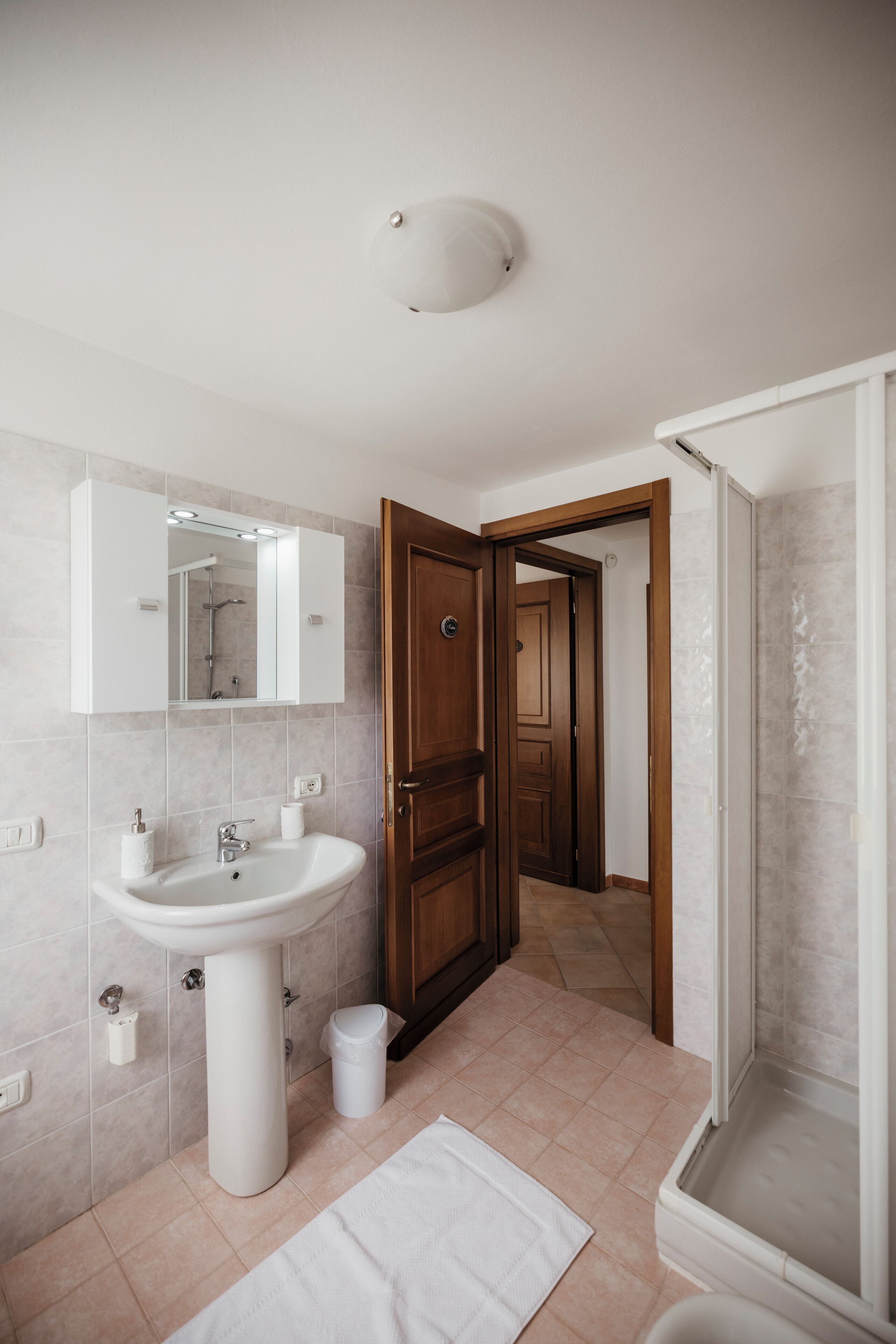 A bathroom with a sink, mirror, and shower.
