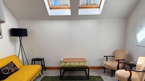 A room with a yellow sofa, a green ottoman, two armchairs, a floor lamp, and a skylight. - Stylish 2BR · Free Parking · Heart of Edinburgh (Edinburgh)